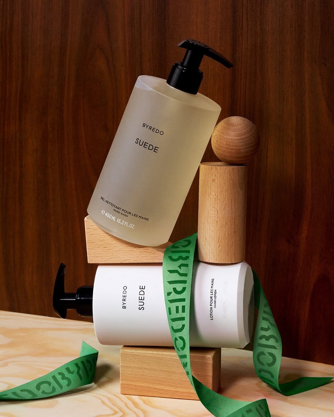Skincare pump bottles styled on wooden blocks with neutral tones